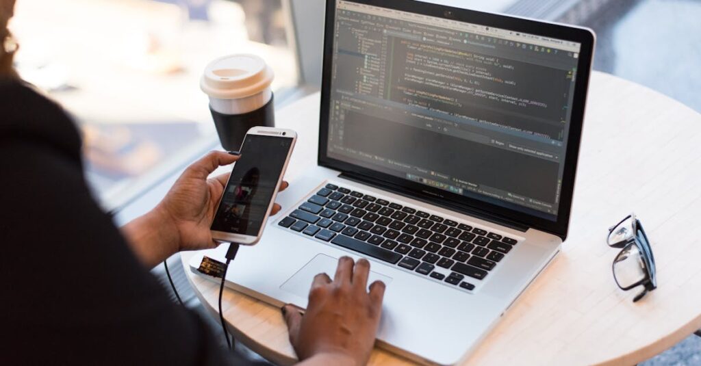 Person Holding Smartphone while using Laptop